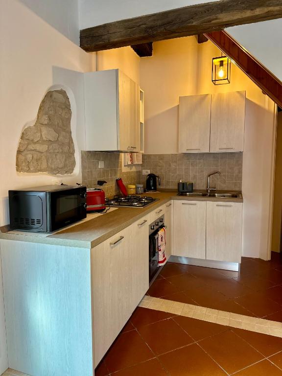 a kitchen with white cabinets and a microwave on the counter at Da Nonna Laura in Follina