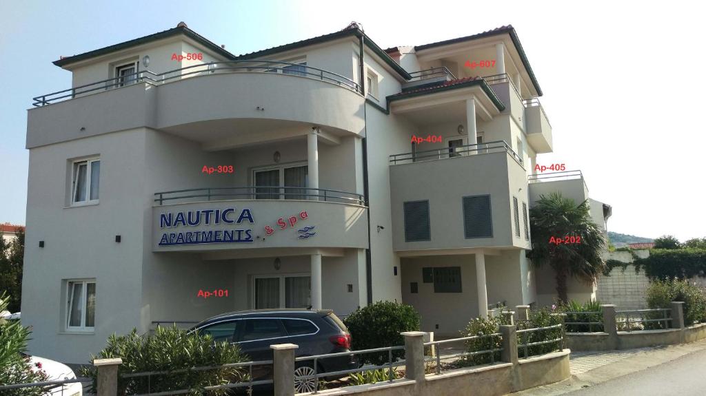 un edificio con un coche aparcado delante de él en Nautica Apartments, en Betina