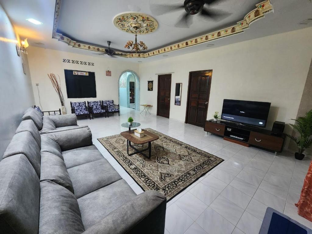 a living room with a couch and a tv at Raintown RR Homestay in Kamunting