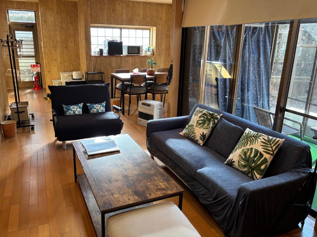 a living room with a couch and a table at コテージ鹿留スマプロハウス ペットと泊まれる一棟貸し 富士急まで20分 2階建て3LDK最大8名 Wi-Fi完備 in Tsuru 