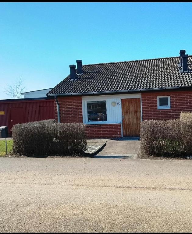 a red brick house with a white door at Villa Glumslov in Landskrona