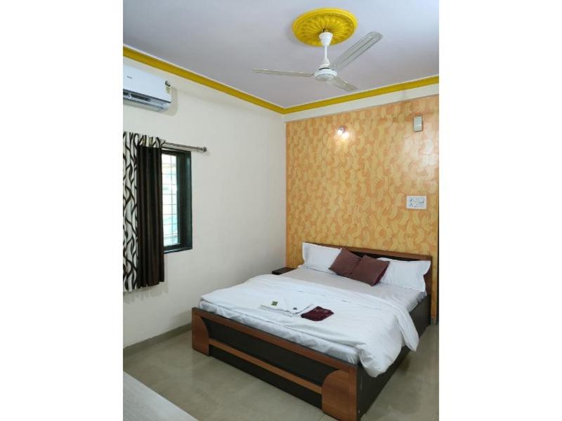 a bedroom with a bed and a ceiling fan at Green Leaf Mini Resort in Mahabaleshwar