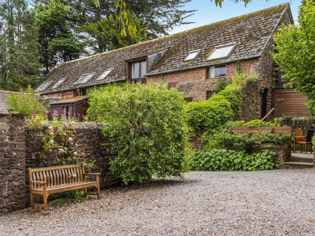 a brick house with a bench in front of it at Cleeve- Ukc4922 in Timberscombe