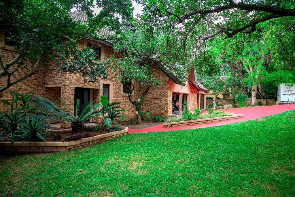 a house with a green lawn in front of it at The View Guesthouse in Nelspruit
