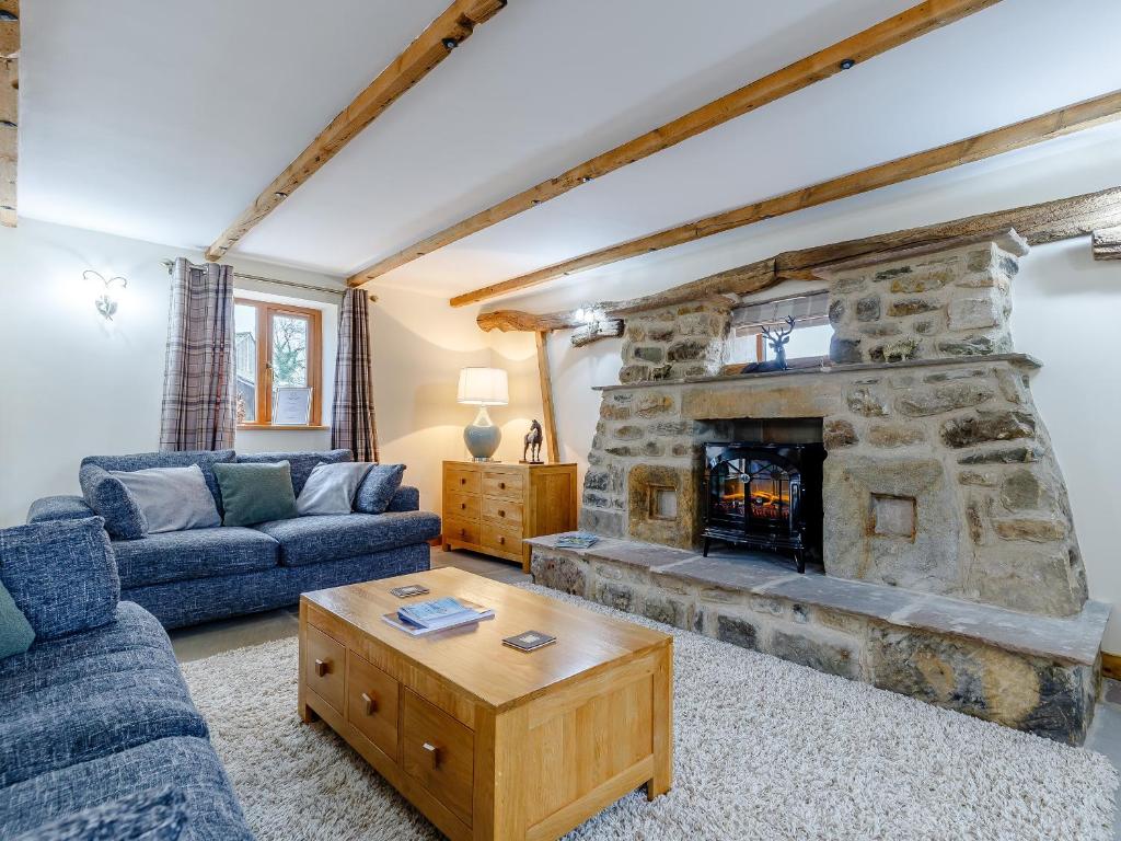 a living room with a large stone fireplace at Barn View in Clay Cross