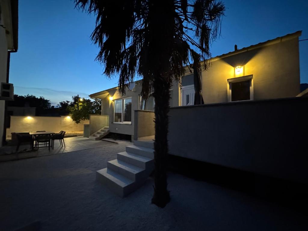 a house with stairs next to a house with a table at Apartmani Antonela in Seline