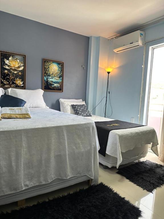 a bedroom with two beds and a window at Flat JK 101 in Juazeiro do Norte