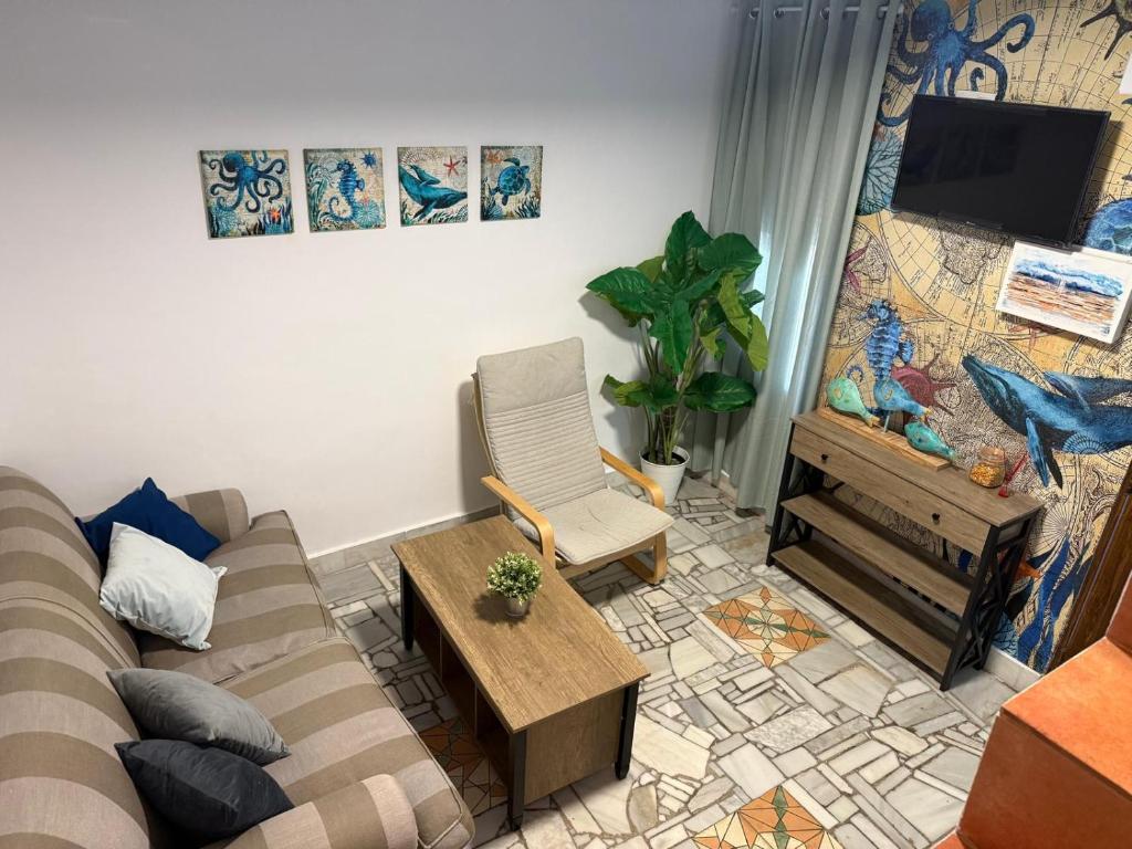 a living room with a couch and a tv at Apartamento Pacífico in Chipiona