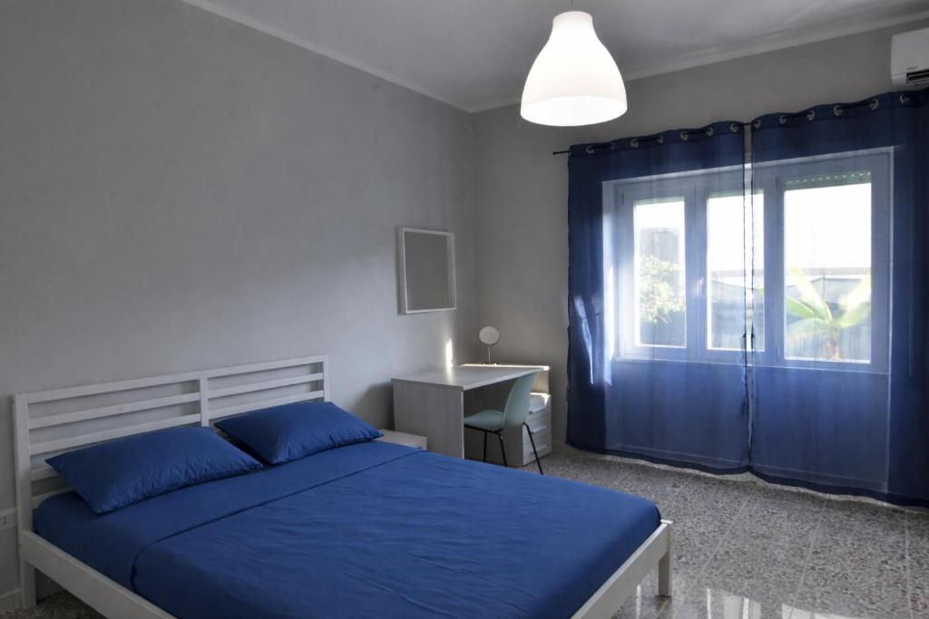 a bedroom with a blue bed and a window at La Spiritiera in Minturno