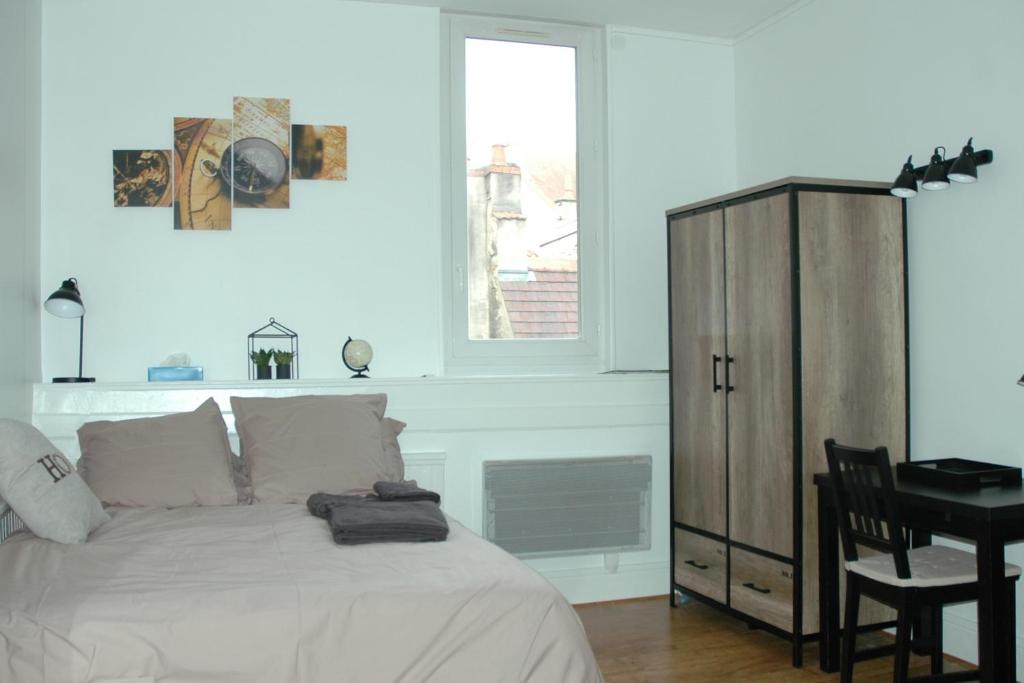 a bedroom with a bed and a desk and a window at Le Cosy Musette - Rue Piétonne in Dijon