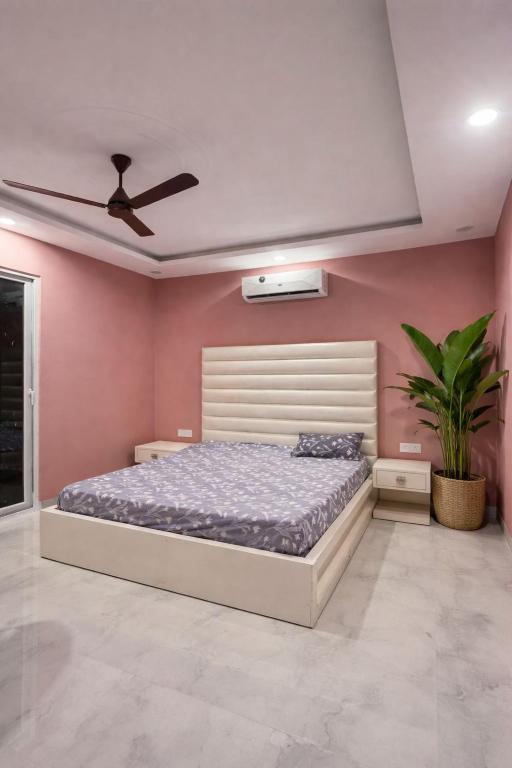 a bedroom with a bed and a ceiling fan at Shiv kashi farm luxury 3bhk with big pool in Noida