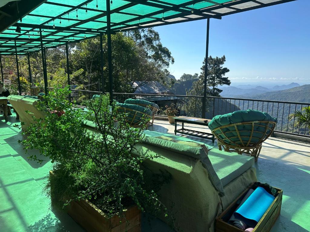 a patio with a couch and chairs on a balcony at Beyond Nomad Luxury Hostel in Ella