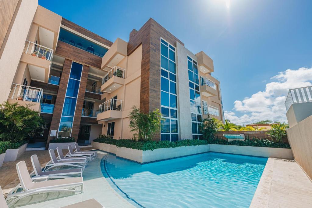 a swimming pool in front of a building at Aracari Residences by Bocobay - Luxury Condos 5 min Walk to Ritz and Palm Beach in Palm-Eagle Beach