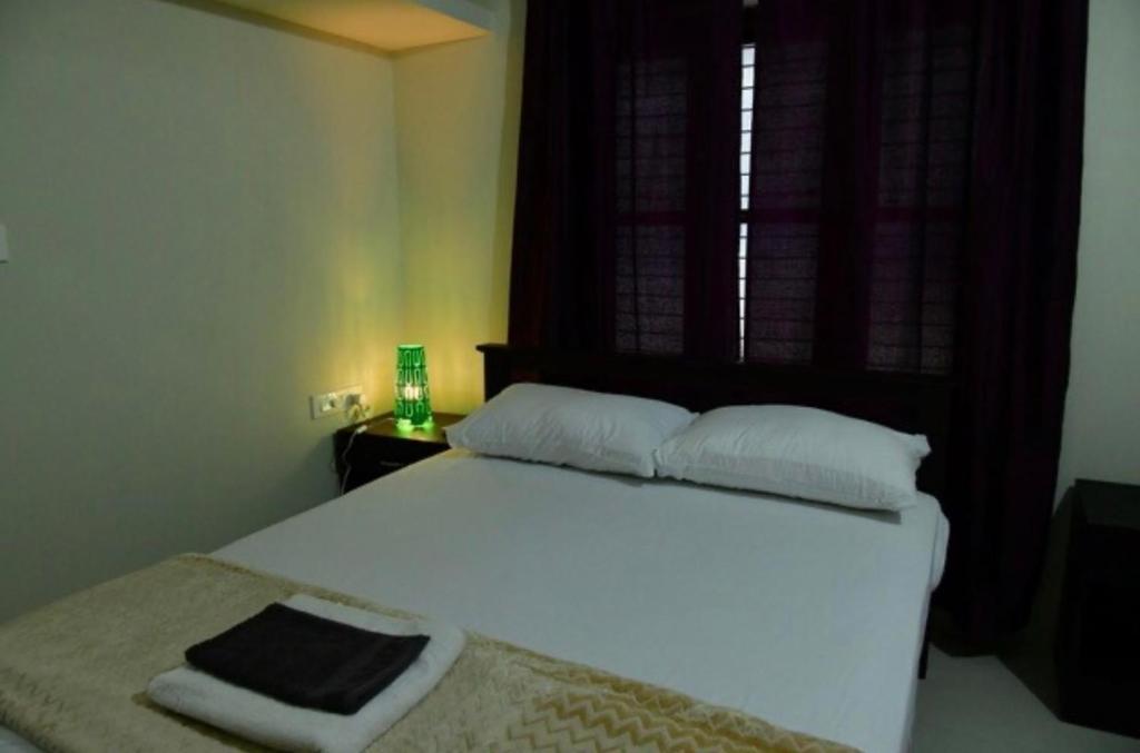 a bedroom with a white bed with a window at Dev Palace in Nawai