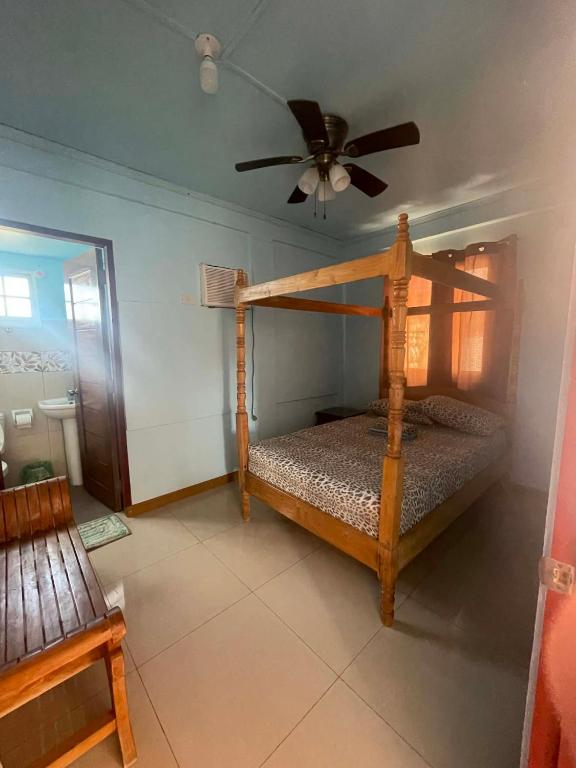 a bedroom with a wooden bed with a ceiling fan at Amerie Rae Resort in Bangui