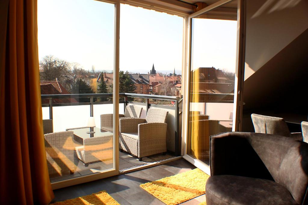 a room with a balcony with chairs and a large window at Ferienwohnungen Augustinerhof in Quedlinburg