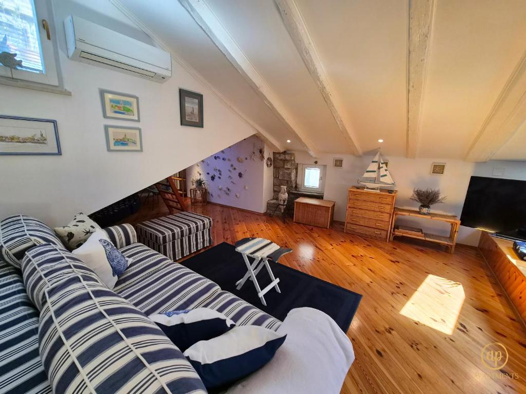 a living room with a couch and a television at Apartment Blue Whale in Piran