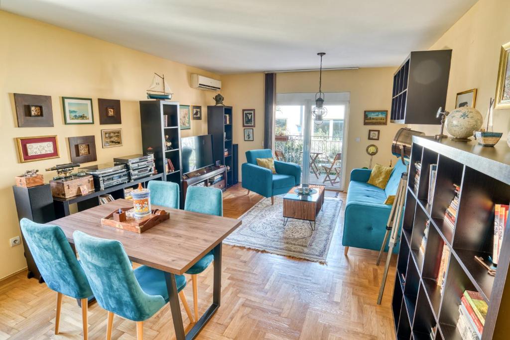 a living room with a wooden table and blue chairs at World Traveler Nest in Kotor