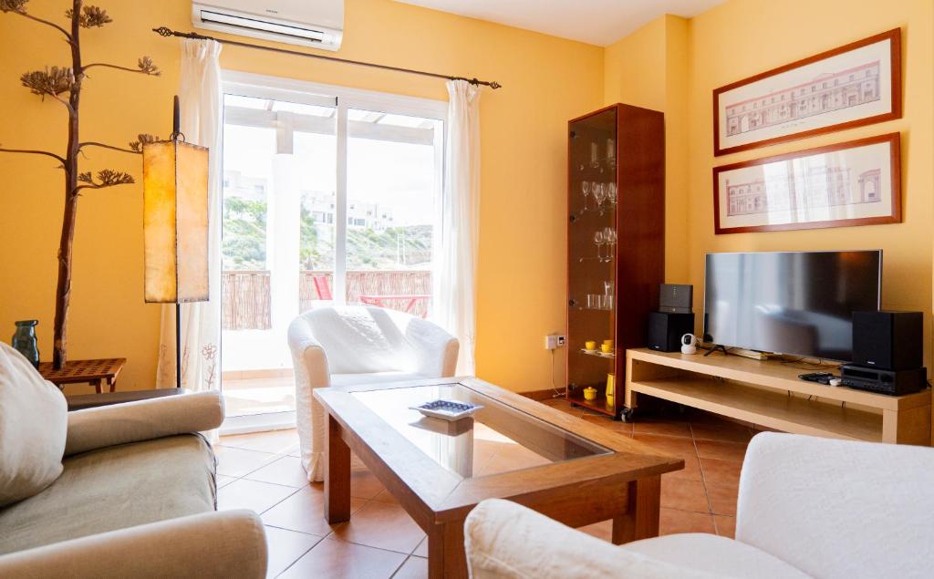 a living room with a couch and a tv at La terraza de Albatros in La Isleta del Moro