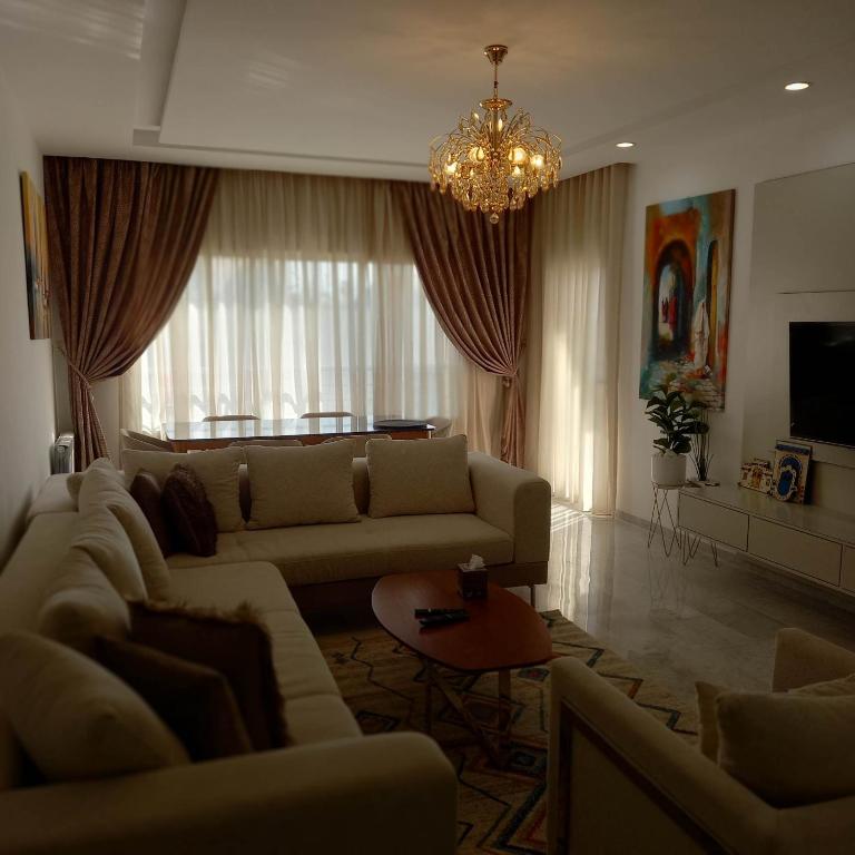a living room with a couch and a chandelier at Appartement Galaxy Hammamet in Hammamet Sud