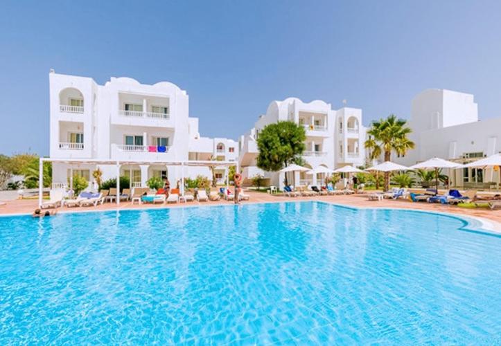 ein großer Swimmingpool vor einem Ferienresort in der Unterkunft Riad Meninx in Bin Rhilouf