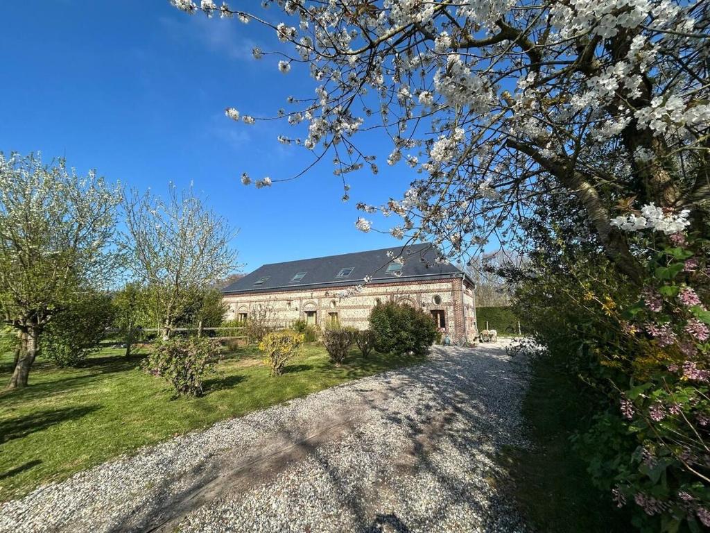 an old stone building with a yard and trees at L'Echo de la Nature in Sasseville