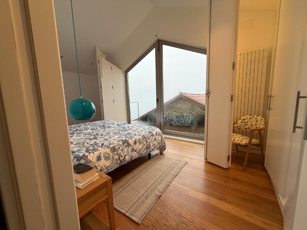 a bedroom with a bed and a large window at Lar do Mar in Beloso
