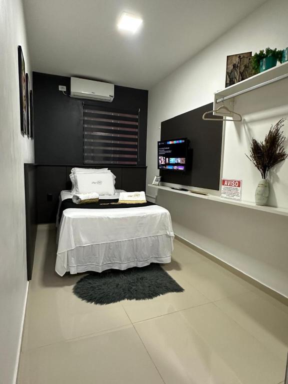 a bedroom with a bed with a black wall at Flat JK 102 in Juazeiro do Norte