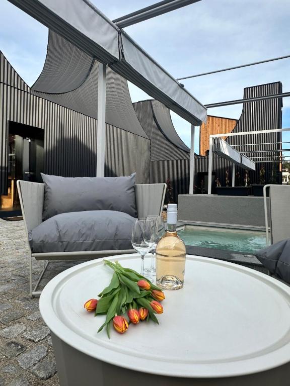 a table with flowers and a bottle and glasses on it at Three Peaks Thermal Villas in Banya