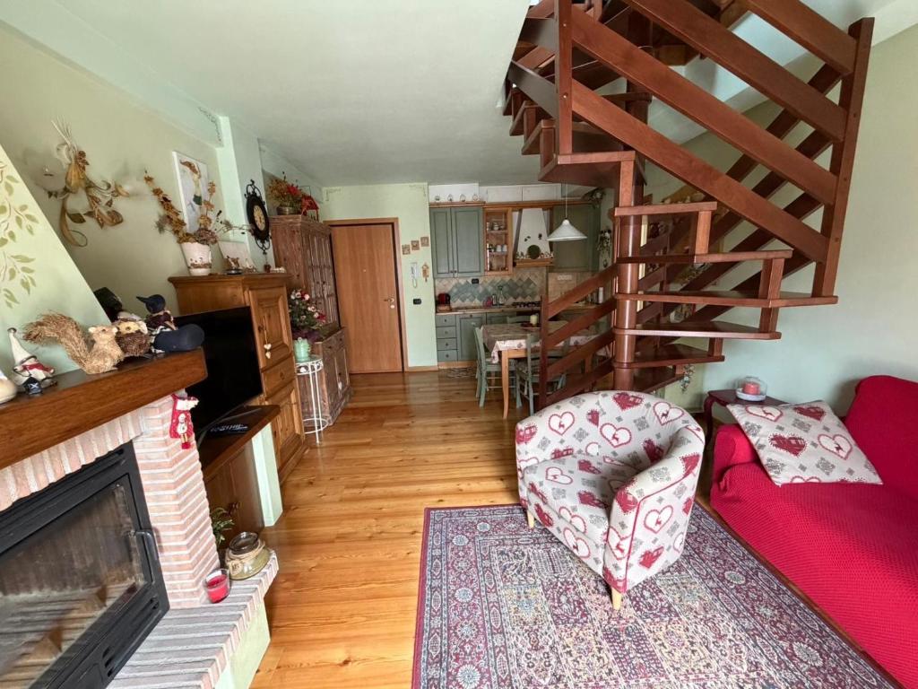 a living room with a couch and a spiral staircase at Appartamento bambi abetone in Abetone