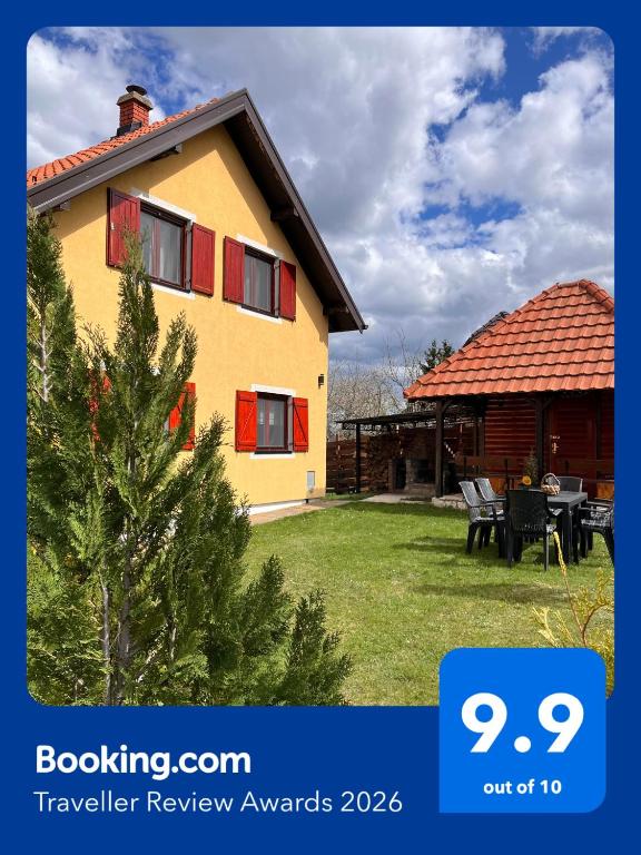 a house with a pine tree in the yard at Tarska Vila - Vera in Kaludjerske Bare