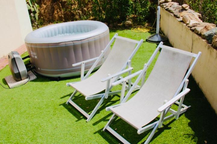 three lawn chairs and a hot tub in a yard at COUNTRY HOUSE HOLIDAY - Olbia in Olbia
