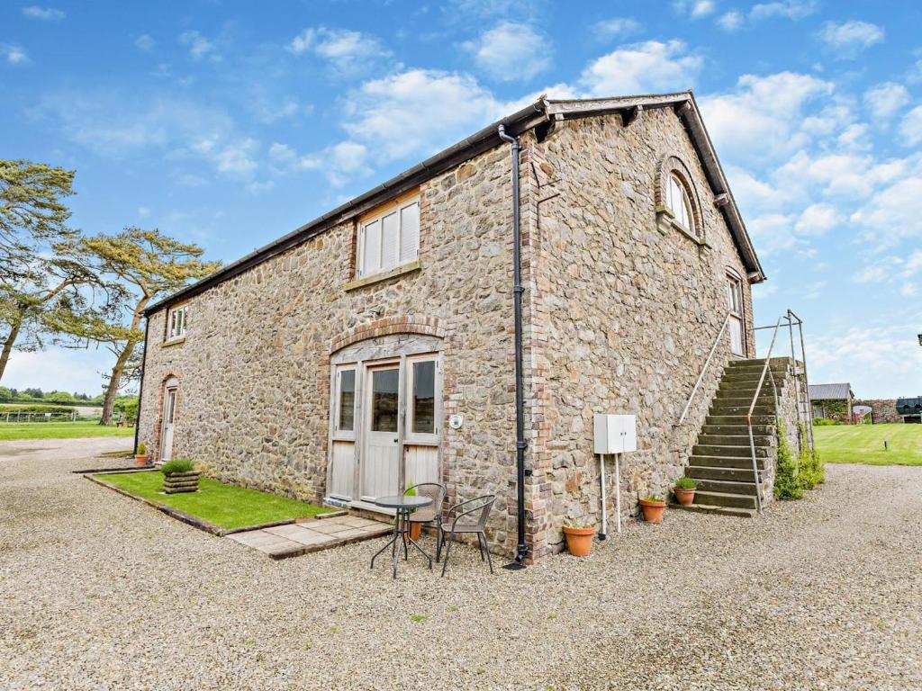 a large stone building with a table and chairs outside at 1 Bed in Bucknell oc-94661 in Letton