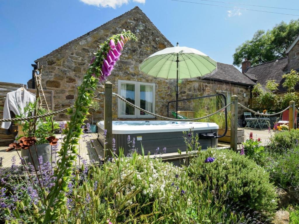 a garden with a hot tub and an umbrella at 1 Bed in Kidderminster oc-94769 in Orleton