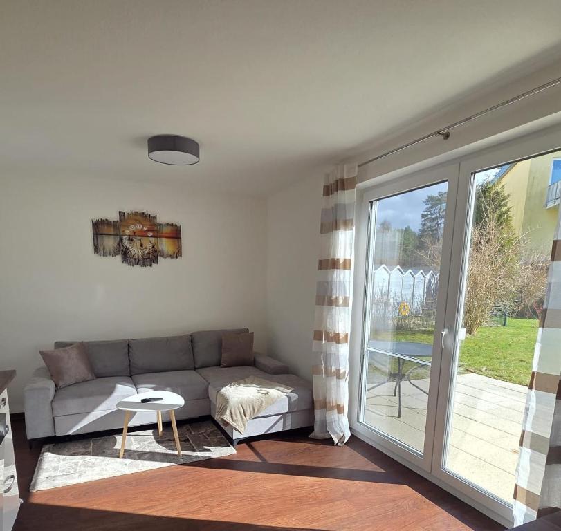 a living room with a couch and a sliding glass door at Seeschwalbe in Graal-Müritz