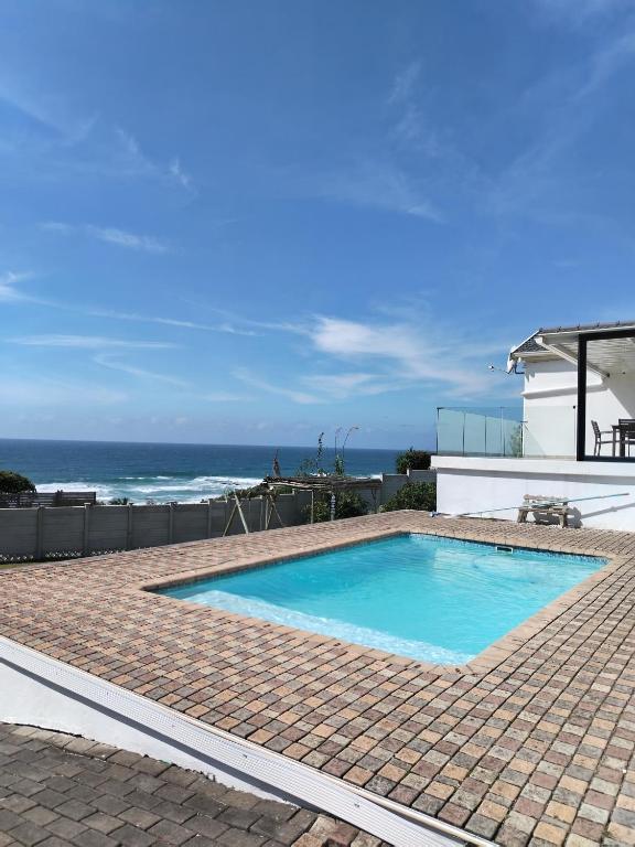 a swimming pool with the ocean in the background at Shotleft on Wye RD in Margate