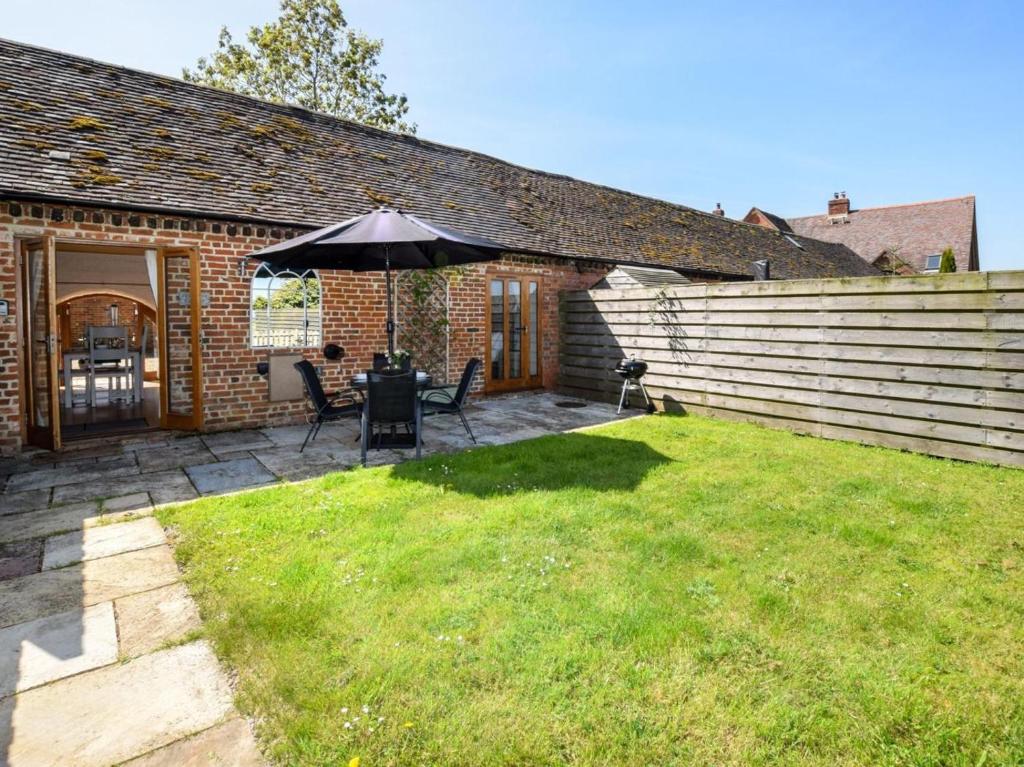 a patio with a table and an umbrella at 1 Bed in Evesham oc-89306 in Church Lench
