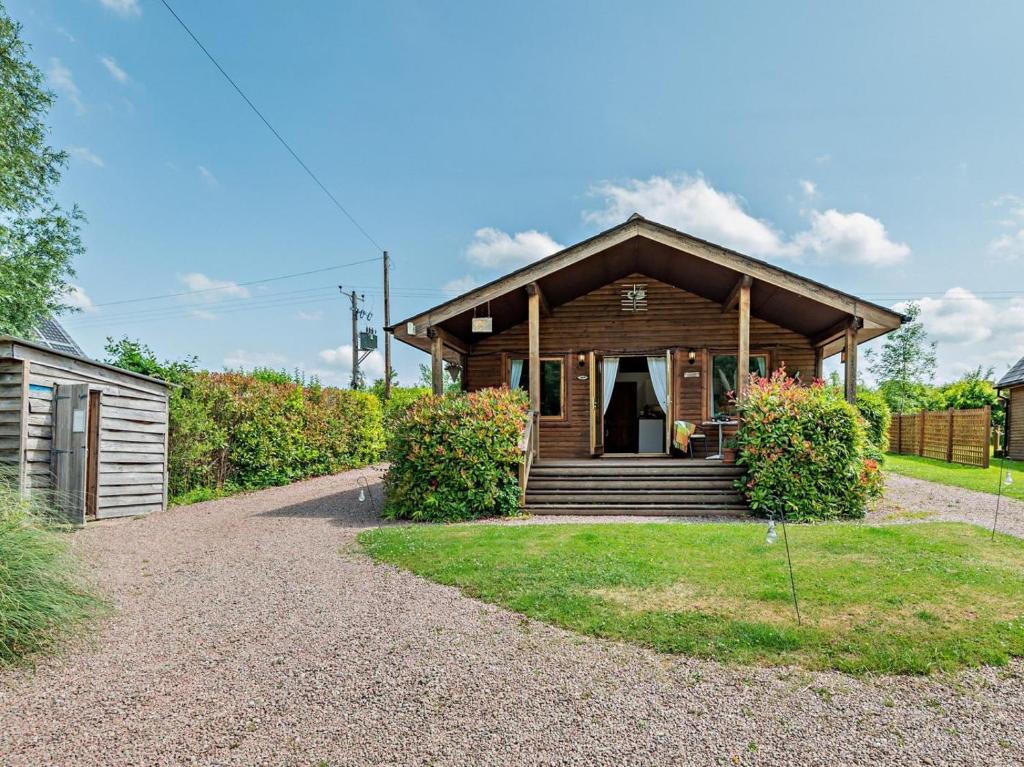 a wooden house with a pathway leading to it at 2 Bed in Ledbury oc-77377 in Yatton