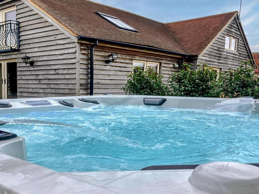 a large hot tub in front of a house at 2 Bed in Thame oc-cc068 in North Aston