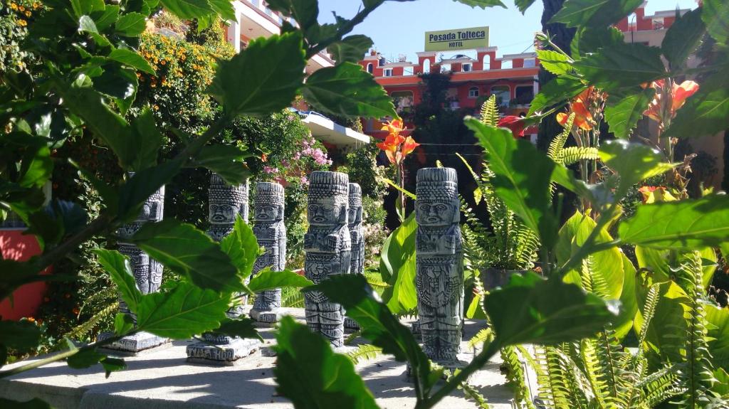 um grupo de estátuas num jardim com plantas em Hotel Posada Tolteca em Tula de Allende