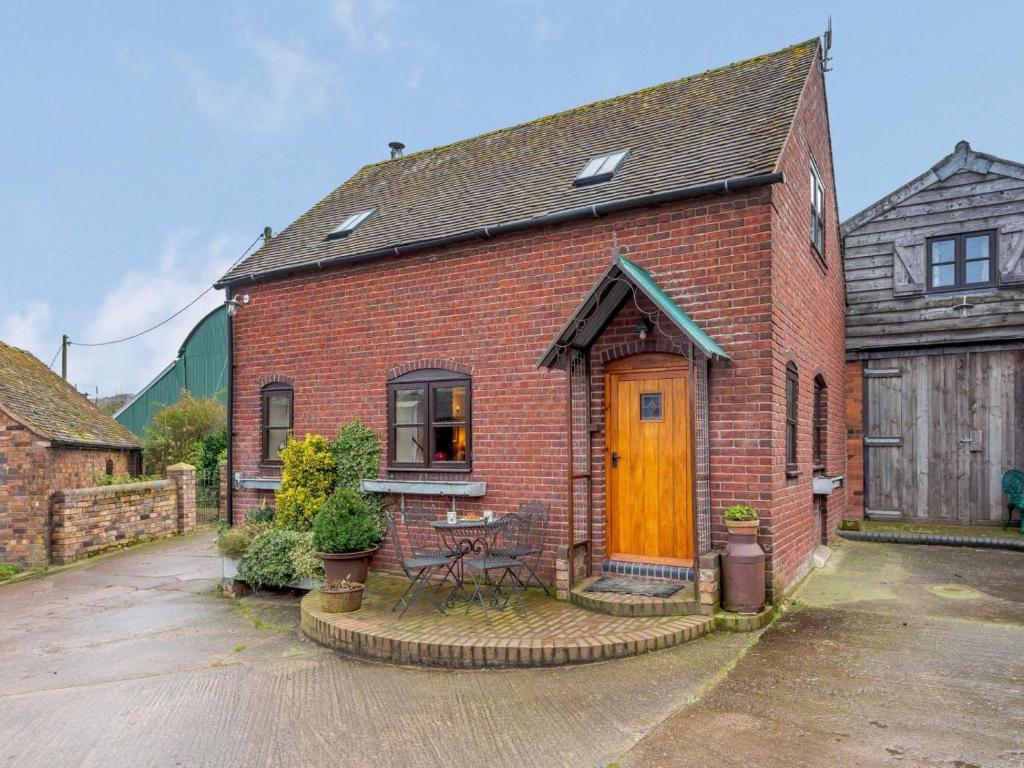a brick house with a wooden door and a table at 2 Bed in Shrewsbury oc-86590 in Leighton