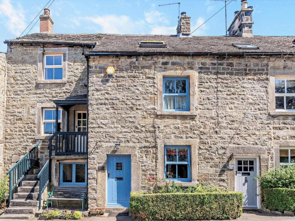 an old stone house with a blue door at 3 Bed in Baslow oc-pk908 in Baslow
