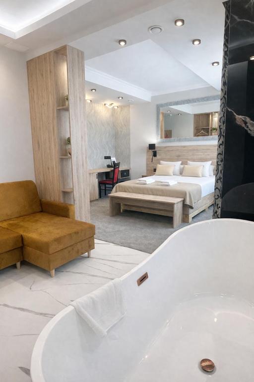 a bathroom with a tub and a bedroom with a bed at Hotel Ajax in Janki