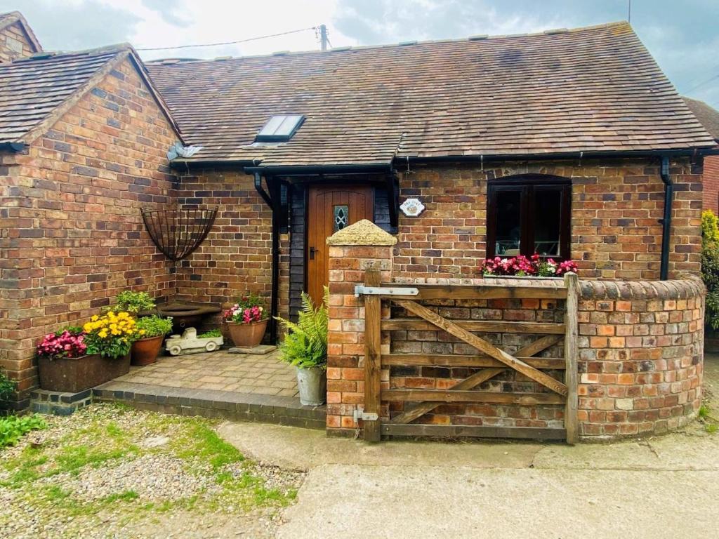 a brick house with a wooden gate in front of it at 1 Bed in Leighton oc-80726 in Leighton