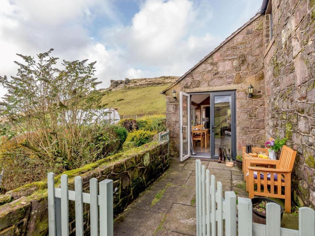 a stone cottage with a white fence next to it at 1 Bed in Buxton oc-74351 in Flash