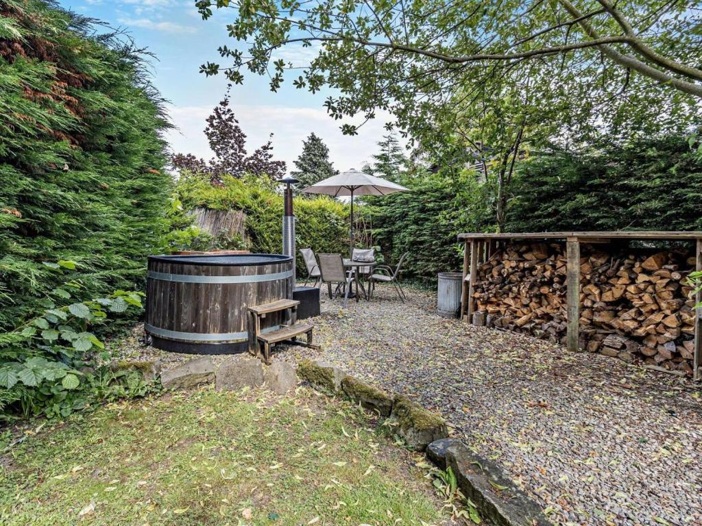 a hot tub in a backyard with a table and a bench at 2 Bed in Oswestry oc-76537 in Gobowen