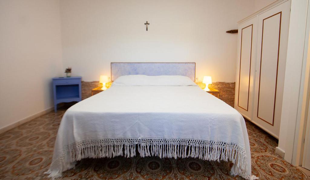 a bedroom with a large white bed with two lamps at Agriturismofaucci in Campo nell'Elba