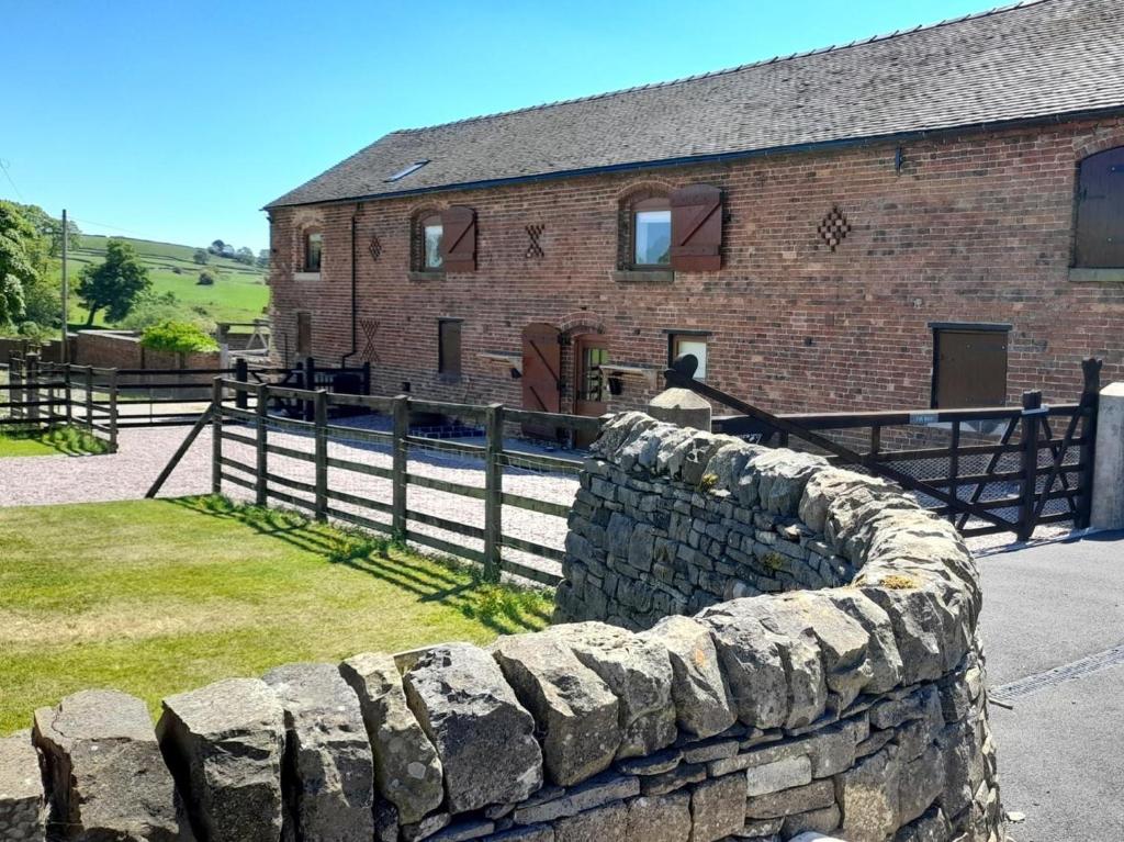 a stone fence in front of a brick building at 5 Bed in Leek oc-79543 in Grindon