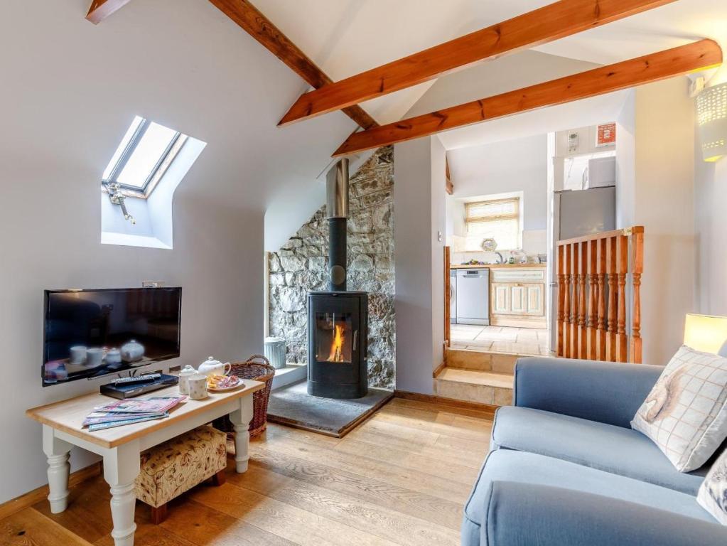 a living room with a blue couch and a fireplace at 1 Bed in Wotton -under- Edge oc-earba in Charfield