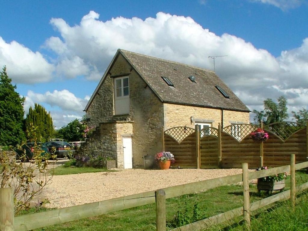 a small stone house with a fence in front of it at 2 Bed in Cirencester oc-cc094 in Ewen